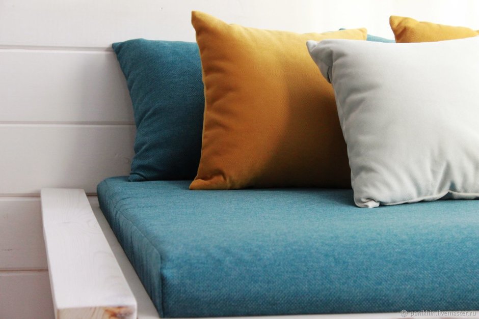Оранжевый диван с подушками в интерьере