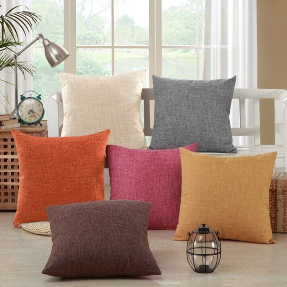 Серый диван с оранжевыми подушками