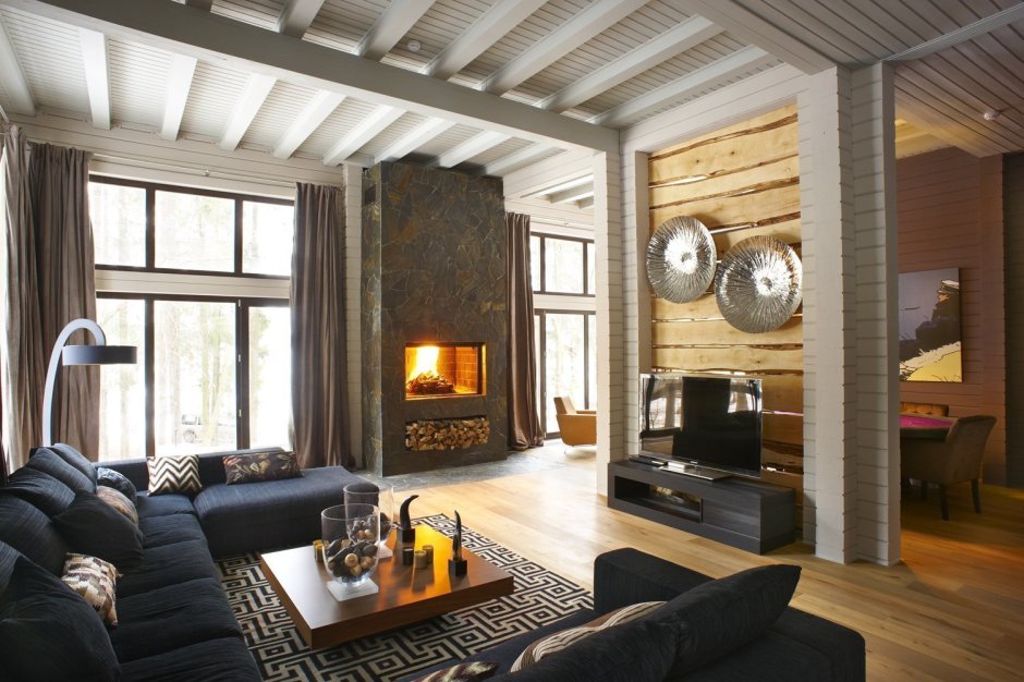 Интерьер гостиной с камином в деревянном доме