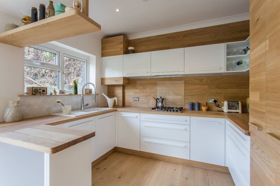 Белая кухня с деревянной столешницей с окном