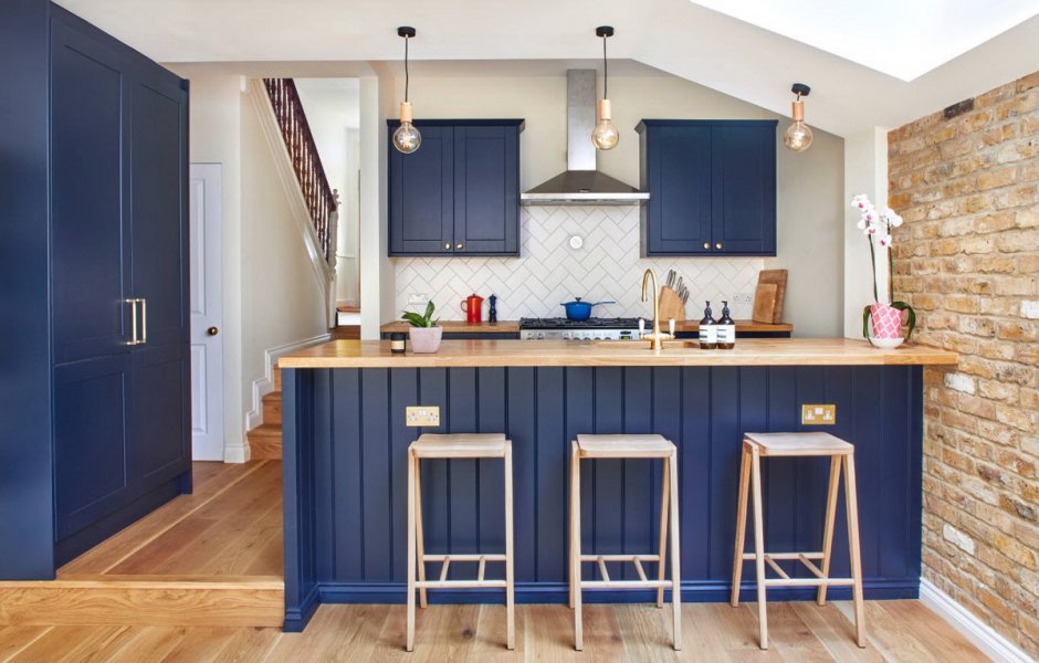 Синяя кухня с деревянной столешницей в интерьере в доме