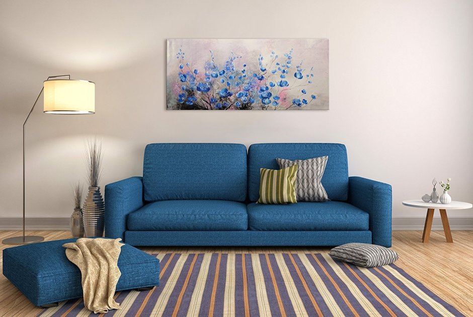 Синий диван на фоне стены