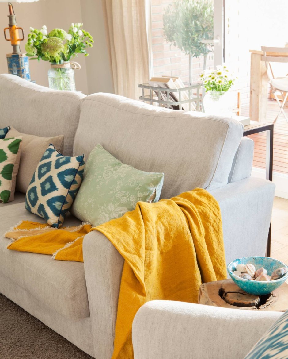 Синий диван с желтыми подушками