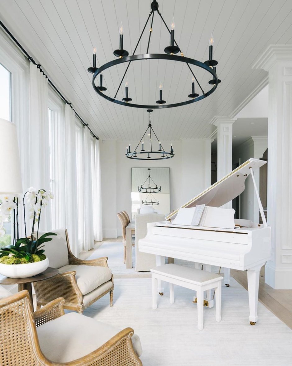 Белое пианино в интерьере посреди комнаты