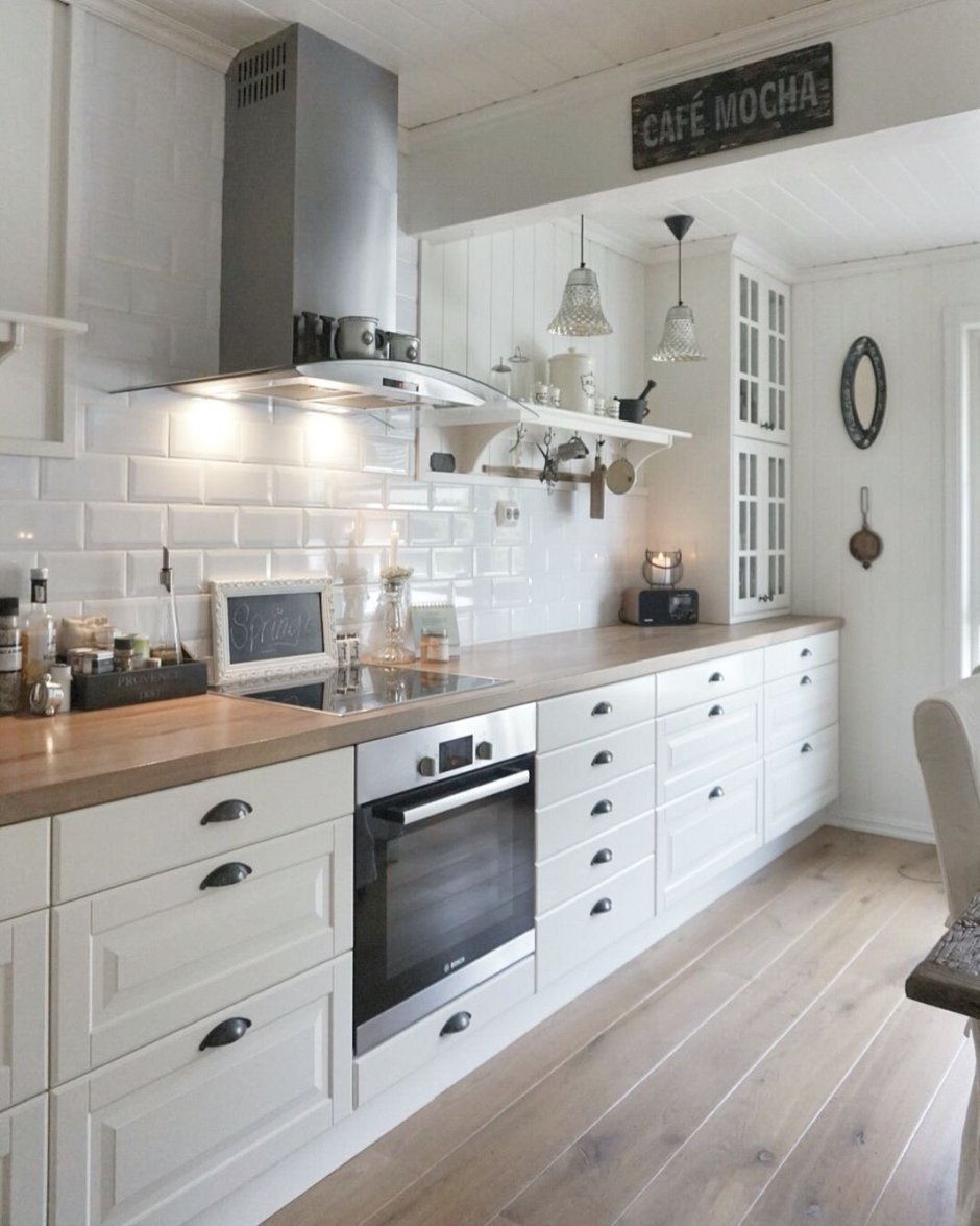 Белая кухня с деревянной столешницей и фартуком пэчворк