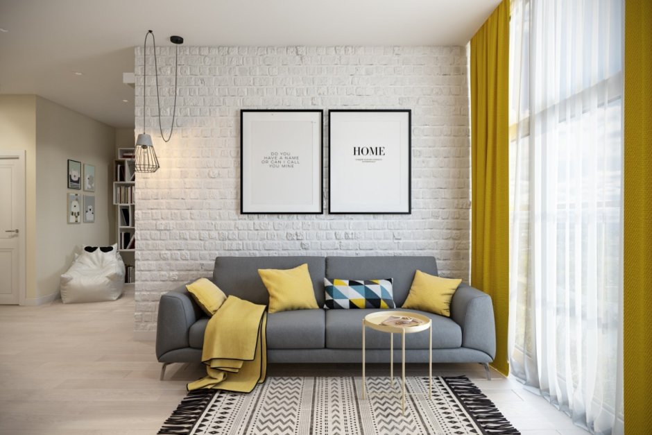 Серый диван на фоне желтой стены