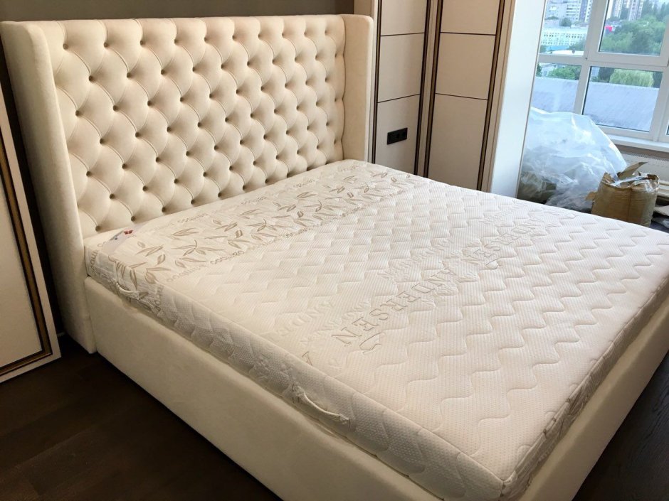Белая кровать с каретной стяжкой