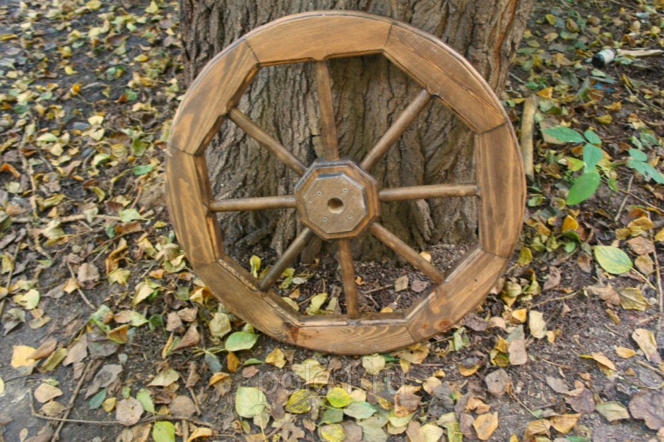Старое колесо деревянное на стене