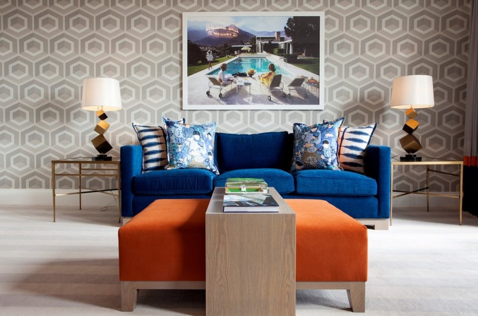 Синий диван и оранжевые обои в интерьере