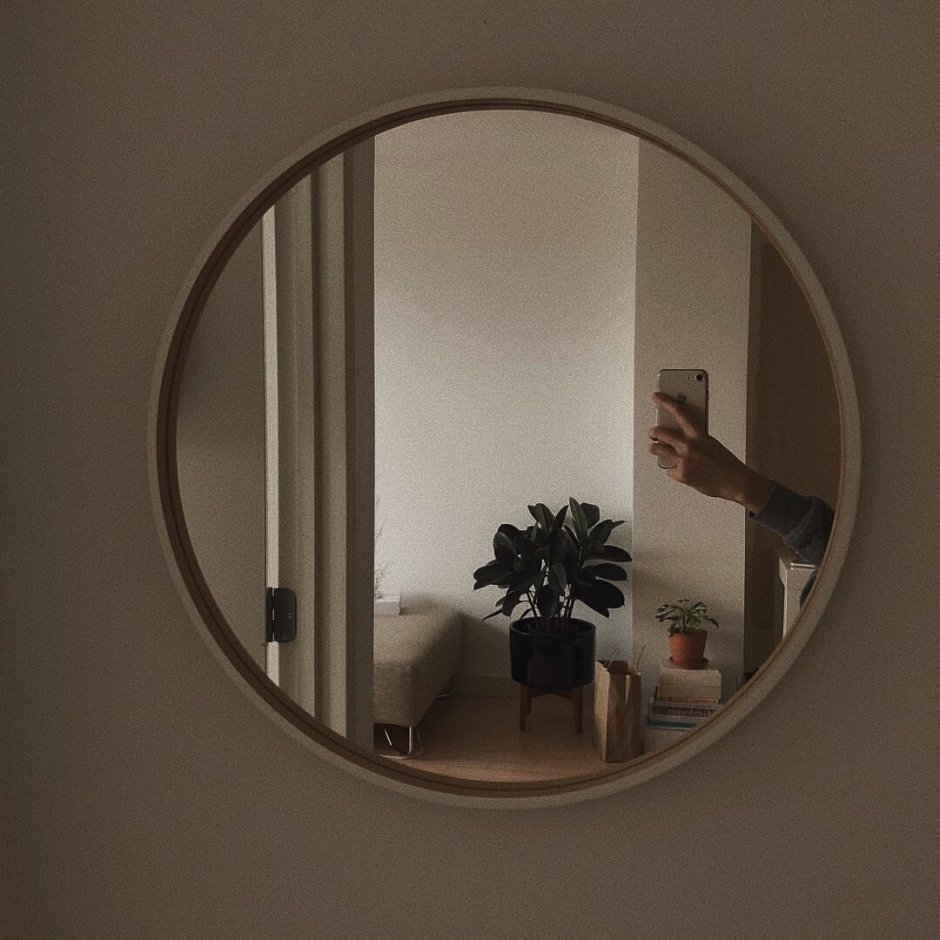 Овальное зеркало за диваном