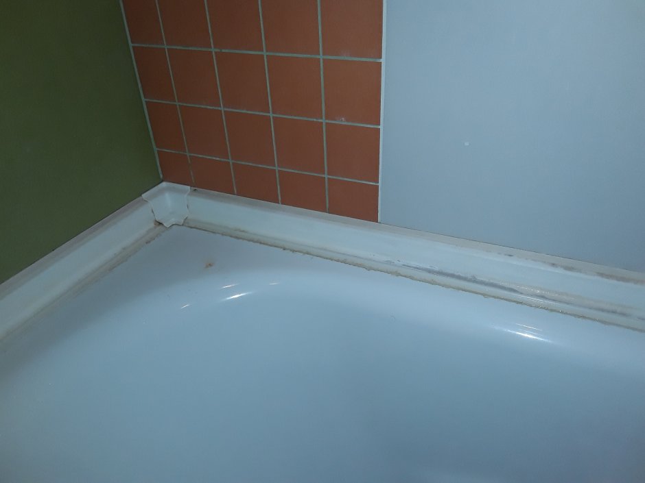 Замазка между ванной и стеной
