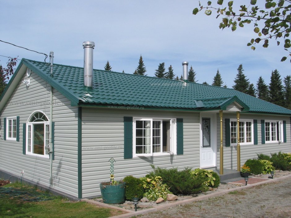 Серый дом с зеленой крышей