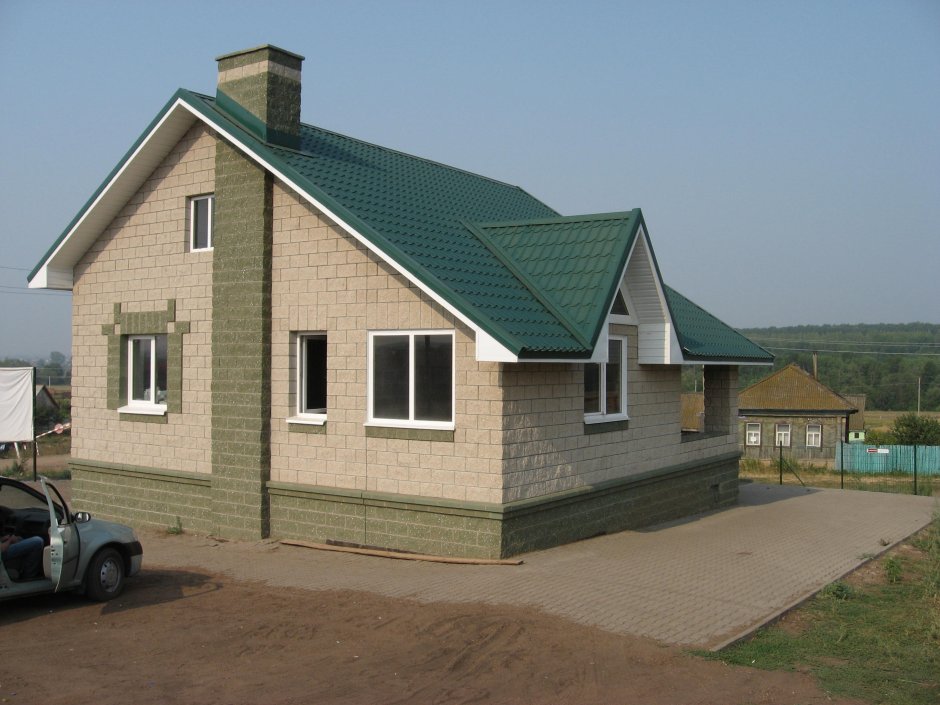 Дом из кирпича с зеленой крышей